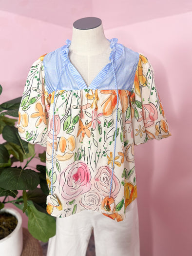 floral top with blue and white neckline 